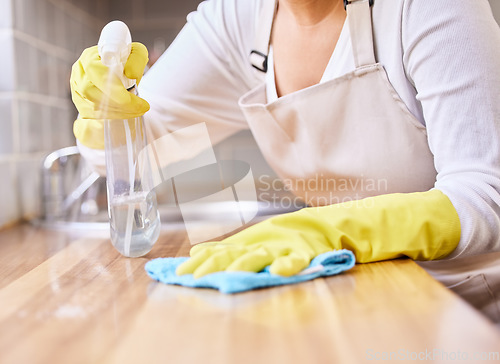 Image of Woman, spray bottle and hands cleaning table in housekeeping, hygiene or disinfection with gloves in kitchen. Closeup of female person wiping surface, counter or furniture in bacteria or germ removal