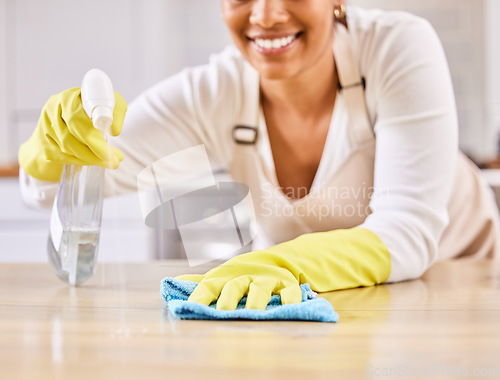 Image of Happy woman, spray bottle and hands cleaning table in housekeeping, hygiene or disinfection in kitchen. Closeup of female person gloves wiping surface counter or furniture in bacteria or germ removal