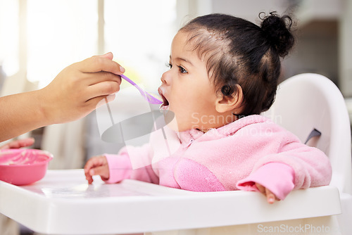 Image of Hand, spoon and child food in chair for baby development, nutrition meal or dinner snack. Kid, feed and eating breakfast hungry for parent care or love for lunch together, diet vitamin in kitchen