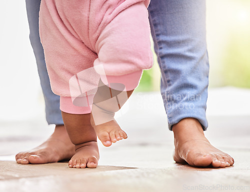 Image of Mother, baby feet and walking with help and support or care with milestone and first steps. A woman parent and girl child walk barefeet with a mom for development in a family home for growth and love