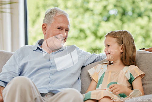 Image of Conversation, smile and grandfather with child on a sofa bonding, relaxing and talking at home. Happy, family and senior man speaking to young girl kid on a couch in the living room at modern house.