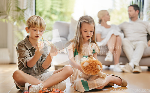 Image of Brother, sister and sibling children with toys on the floor of a living room in their home together. Family, cute boy and girl kids playing in their apartment with parents for weekend bonding
