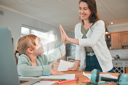 Image of Mom, girl and high five in home with learning, development and support with smile, documents or laptop. Education, mother and daughter with cheers for achievement, progress or growth in online course