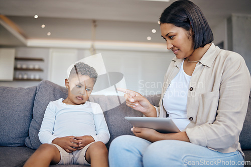 Image of Mother, child and scolding or discipline, tablet and punishment at home. Parent and daughter, communication and disappointed for cyberbullying, bad behaviour and frustrated for digital mistake