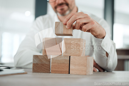 Image of Building blocks, hands and business man in office for future planning, insurance or finance. Wood, puzzle and closeup of male entrepreneur with asset management, investment or financial security