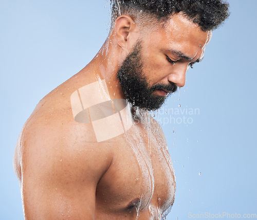 Image of Shower, washing and man with water on blue background for cleaning, hygiene and skincare in studio. Dermatology, bathroom and person with splash, drops and cosmetics for wellness, health or self care