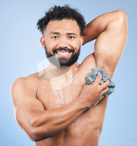 Image of Shower, washing and portrait of man with sponge for cleaning, soap hygiene and skincare on blue background. Dermatology, bathroom and person with splash, foam and cosmetics for wellness in studio