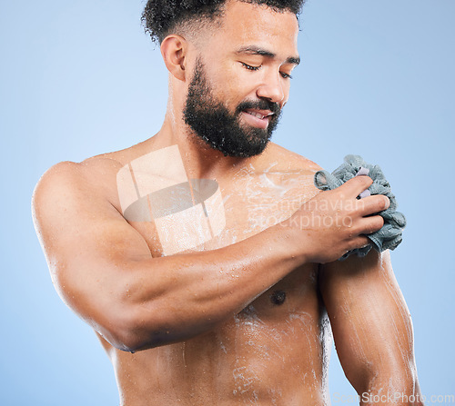 Image of Shower, washing and man with sponge and soap for cleaning, hygiene and skincare on blue background. Dermatology, bathroom and person with splash, foam and cosmetics for wellness or health in studio