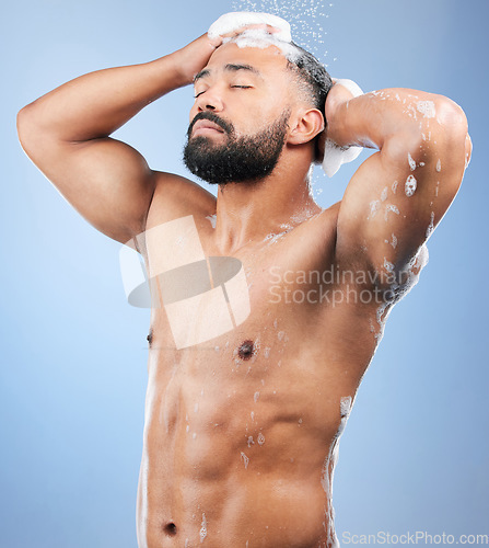 Image of Shower, washing hair and man with foam in studio for cleaning, hygiene and skincare on blue background. Dermatology, bathroom and person with soap, shampoo and cosmetics for wellness and health