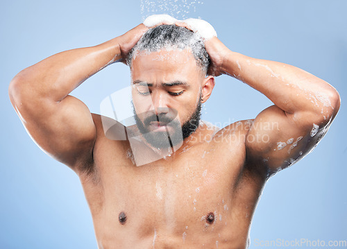 Image of Shower, washing hair and man with water in studio for cleaning, hygiene and skincare on blue background. Dermatology, bathroom and person with shampoo, foam and grooming for wellness and health