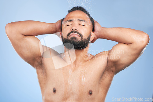 Image of Bath water, shower and man wet, grooming and morning self care maintenance, bathroom body cleaning or spa salon wellness. Skincare liquid wash, eyes closed or studio person hygiene on blue background