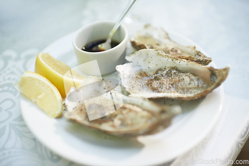 Image of Background, food and plate of oysters in restaurant for lunch, dinner and eating appetizer of gourmet cuisine. Closeup, luxury seafood diner and serving of healthy shellfish dish on table with lemon