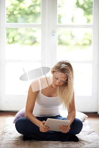 Image of Woman, tablet and sitting on living room floor for social media, entertainment or reading at home. Female person or blonde in relax with technology for series, ebook or connection in lounge at house