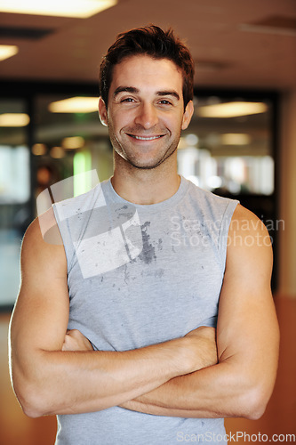 Image of Man, smile and pride or confidence for fitness, health and wellness or body transformation at gym. Happy male person, motivation and portrait for training, workout and arms crossed for challenge