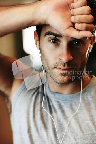 Image of Man, earphones and music for fitness, portrait and workout at gym, streaming radio and podcast or audio. Male person, face and playlist for exercise, confident and train for wellness, cardio or ready