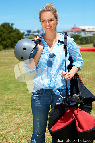 Image of Skydiving, portrait and woman outdoor for adventure with gear and helmet in countryside with a smile. Happy, person and skydiver ready to start, stunt or risk danger with equipment for security