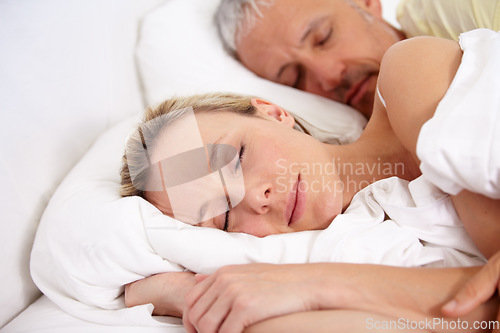 Image of Love, tired and mature couple sleeping in bed for romantic cuddling together on weekend morning. Calm, peaceful and senior man and woman taking a nap in bedroom for bonding at modern apartment.