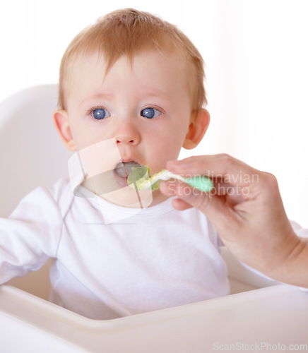 Image of Sweet, spoon and baby eating vegetables in feeding chair in a studio for health and nutrition. Cute, natural and boy newborn, child or kid enjoying a meal for wellness diet by white background.