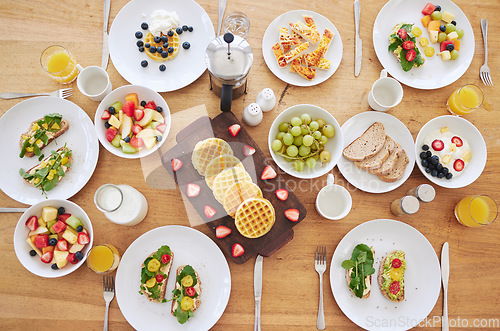 Image of Table, breakfast and health with food, fruits and bread in home with plate, cutlery or salad. Above countertop, container or diet for nutrition with waffles, toast or juice for eating, drink and milk