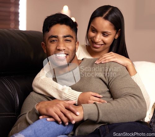 Image of Happy couple, portrait and hug on sofa, home and relax with love, bonding and together in living room. Man, woman and smile with care, lounge couch and embrace in house, trust or connection in Mumbai