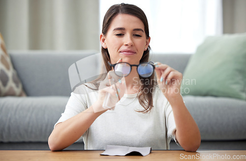 Image of Home, cleaning and glasses with woman, lens and eye care protection with liquid, bottle and optic maintenance. Person, house or woman with eyewear, frames or cloth to wipe spectacle for clear vision