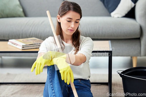 Image of Cleaning, burnout and an unhappy woman in the living room of her home for housework chores. Sad, tired or exhausted with a young person looking bored in her apartment for housekeeping responsibility