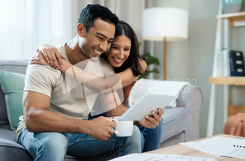 Image of Happy couple, hug and tablet for social media on sofa in house for funny joke, meme or post. Man, woman and smile in excitement with coffee for article on internet, mobile app and web for relaxing