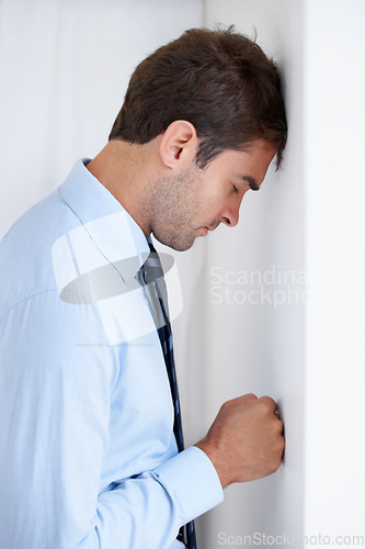 Image of Frustrated businessman, stress and mistake in anger, anxiety or burnout with fist on wall at office. Upset man or employee in financial crisis, depression or mental health problems at workplace