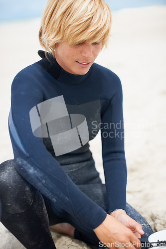 Image of Fitness, sports and a surfer getting ready on the beach for leisure, recreation or a summer hobby. Exercise, surfing or training with a happy young athlete on the sand at the start of his workout