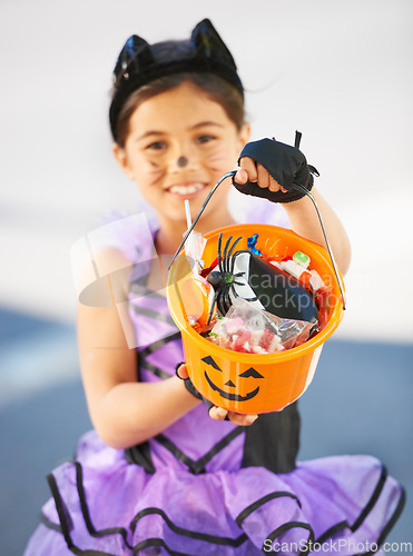 Image of Halloween, child or trick and treat bucket portrait outdoor in neighborhood for fun and dress up. A young girl kid excited with happiness, celebrate holiday and candy or sweets for snack in road