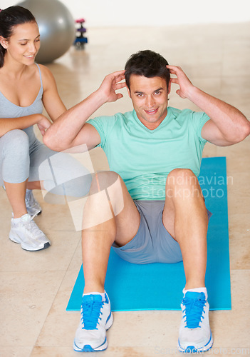 Image of Personal trainer, fitness and portrait of man sit up in exercise and workout for health, wellness and cardio, People, training or coach helping person with core, crunches and pilates routine in gym