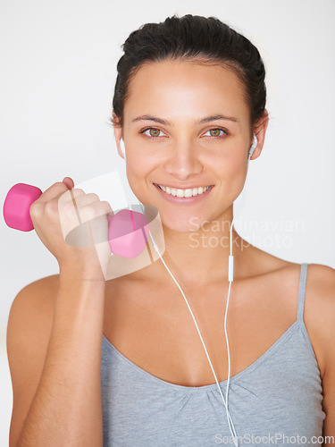 Image of Portrait, weightlifting and happy woman with headphones for fitness and arm strength. Smile, dumbell and happy female athlete with music for training and workout on a white studio background