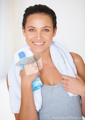 Image of Happy woman, portrait and fitness with water bottle for hydration or natural nutrition at gym. Face of female person smile with mineral drink and towel for exercise, workout or training in wellness