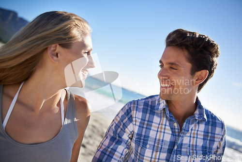 Image of Couple, walk and smile on beach, talk and outdoor in summer sunshine for vacation, thinking or travel. Man, woman and happy with love, bonding and holiday by ocean for adventure in Naples, Italy