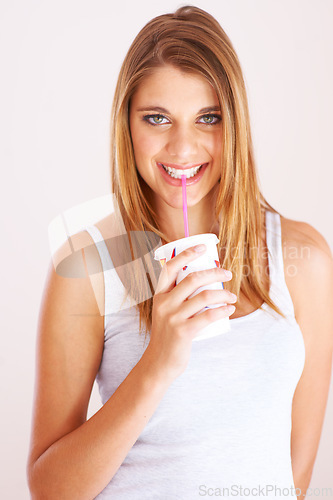Image of Woman, portrait and drink cup of soda, fizzy cola and ice cold milkshake in studio on white background. Thirsty, happy and young girl sip on straw for takeaway smoothie, juice and fast food beverage