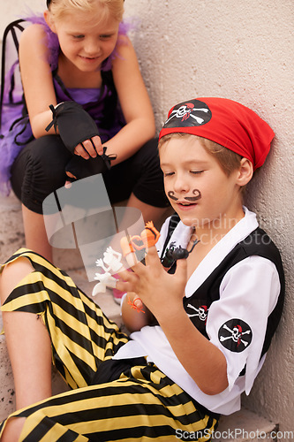 Image of Siblings, playing and halloween costume by outdoor stairs, toys and happiness in childhood. Boy, girl and smile face for holiday with finger puppet games, theme clothes fairy and pirate in backyard