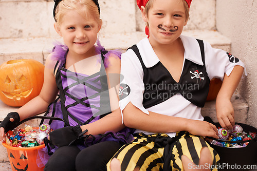 Image of Siblings, portrait and halloween costume on stairs, candy and happiness in childhood. Boy, girl or smile face for holiday party event with trick or treat, theme clothes fairy or pirate by backyard