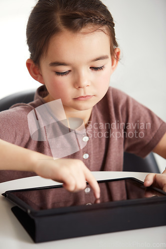 Image of Little girl, tablet and watching in living room for games, online entertainment or research at home. Face of young female person, child or kid with technology for communication or networking at house