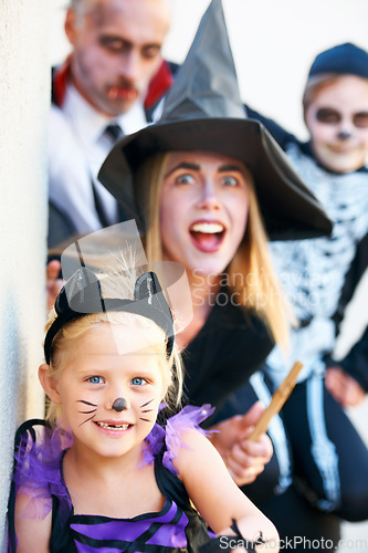 Image of Portrait, halloween and a family in costume for fantasy tradition or holiday celebration. Mother, father and children at a door in trick or treat clothes for dress up on allhallows eve together