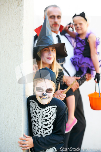 Image of Portrait, halloween and a family in costume for trick or treat tradition or holiday celebration. Mother, father and children at a door in fantasy clothes for dress up on allhallows eve together