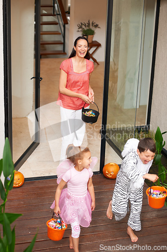 Image of Family house, halloween and children running with candy for fun adventure or vacation tradition. Happy, love and mom watching kids in costume with candy, laugh and energy in costume for holiday prank