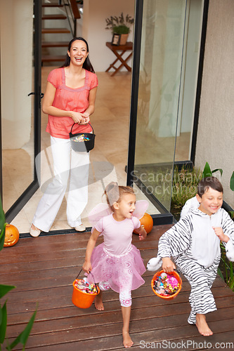 Image of Family home, halloween and children running with candy for fun, adventure or vacation tradition. Happy, love and mother watching excited kids in costume, laugh and playful energy for holiday prank