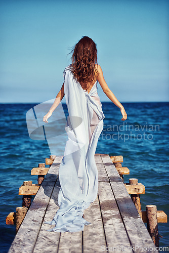 Image of Woman, elegant and promenade with dress by beach, confident and fashion clothes for trendy designer collection. Model, usa and luxury in chiffon gown for fancy, blue and natural for style by ocean