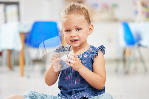 Image of Portrait, kid or little girl with tea cup in kindergarten, daycare or classroom for playing. Youth, happy and smile for fun activity with delicious, fresh and beverage for development of motor skills