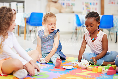 Image of Kids, tea party and playing for fun in school with friends, together and bonding. Diversity, little girls and face with toy on mat for child development, motor skills and growth for future in daycare