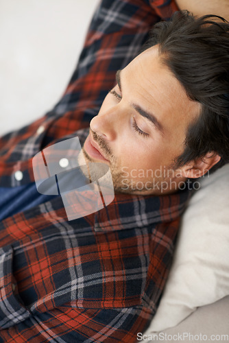 Image of Relax, sleeping and man on sofa in home for afternoon nap, resting and calm in living room. Asleep, eyes closed and face closeup of tired person on couch lying for fatigue, comfortable and wellness