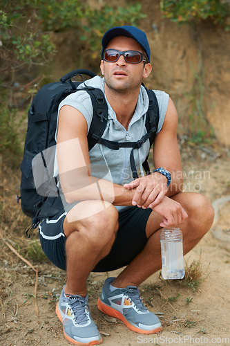 Image of Fitness, man and thinking of nature hiking with water, backpack and energy drink for workout, training and exercise. Hiker, person and planning mountains trail for health, wellness and summer sports