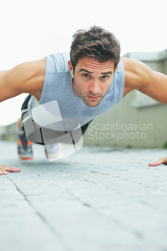 Image of Man, portrait and push ups in fitness for workout, exercise or outdoor training on floor. Muscular male person or athlete lifting body weight for strength, muscle or endurance in health and wellness