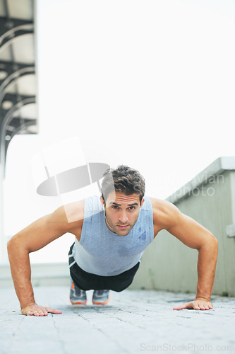 Image of Man, portrait and push ups in fitness for exercise, workout or outdoor training on floor. Muscular male person or athlete lifting body weight for strength, muscle or endurance in health and wellness