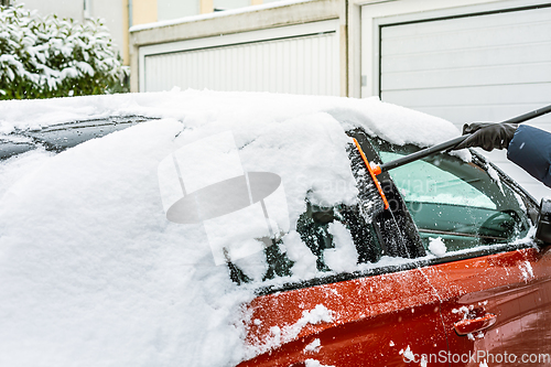 Image of Cleaning snow from windshield. Cleaning and clearing the car from snow on a winter day. 